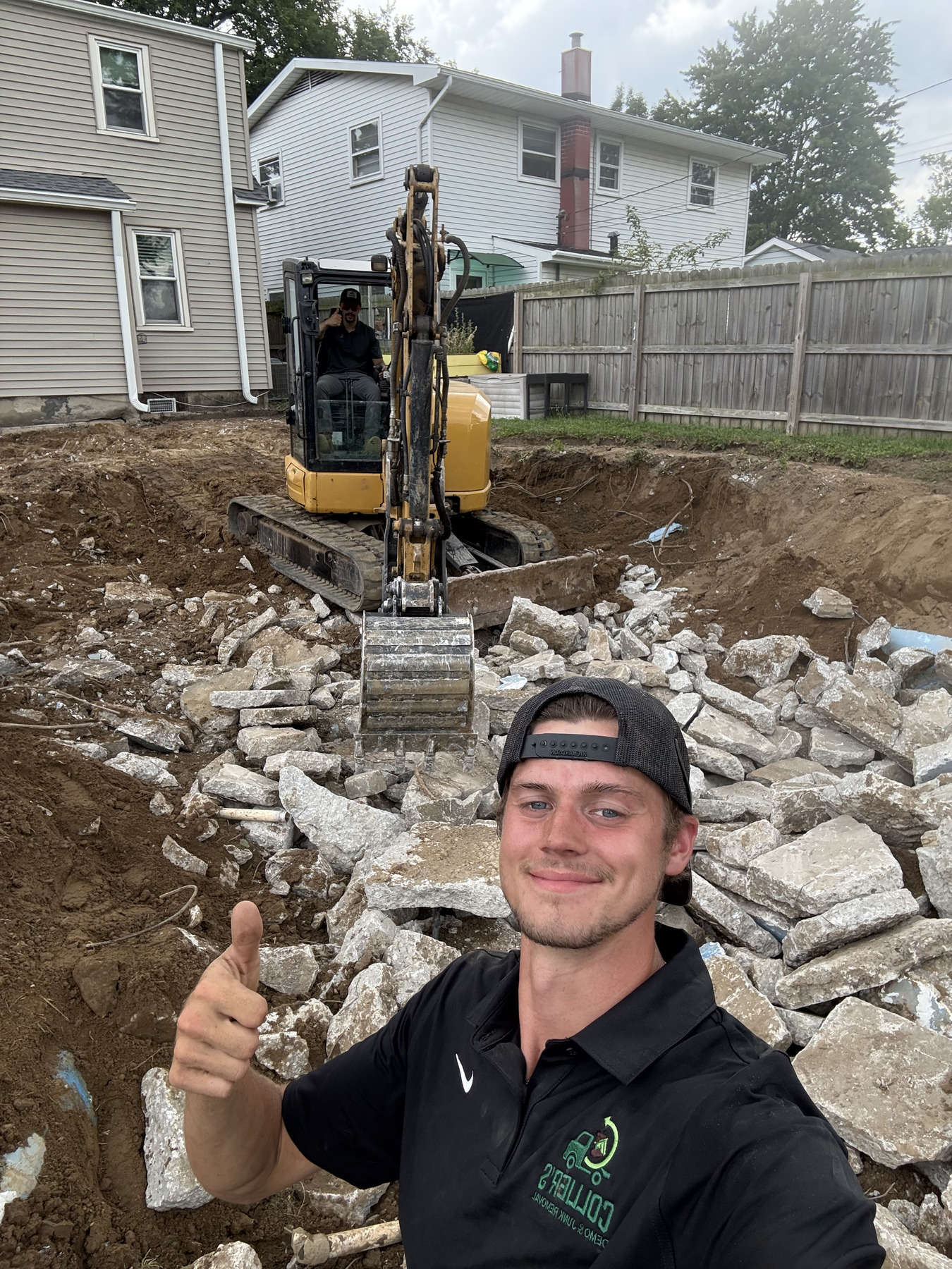 Jake from Collier's in front of an excavator breaking out a concrete slab